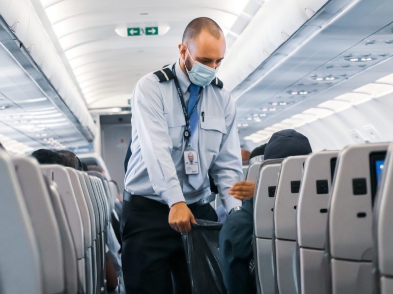 A photo of a masked flight attendant.