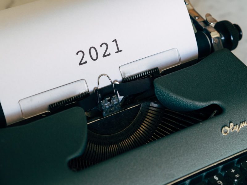 A photo of a typewriter with the year 2021 printed on paper sticking out of it.