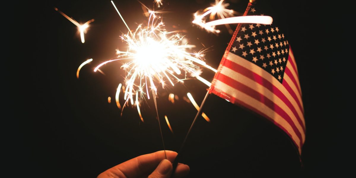 A sparkler and a hand-held American Flag