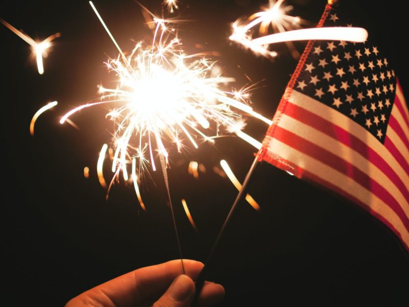 A sparkler and a hand-held American Flag