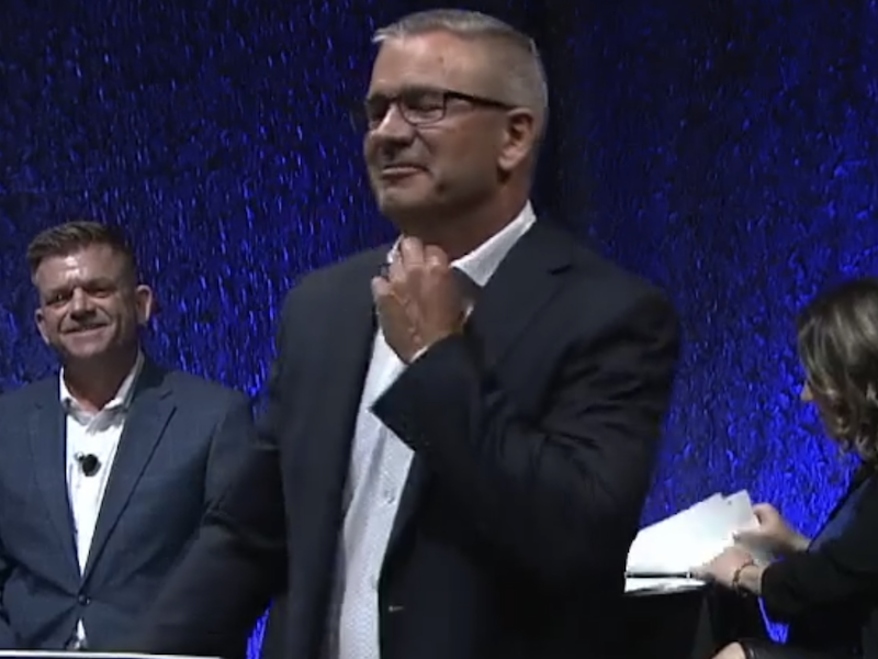 A screenshot of UCP leadership candidate Travis Toews nervously adjusts the tie he’s not wearing during last night’s candidates’ debate.