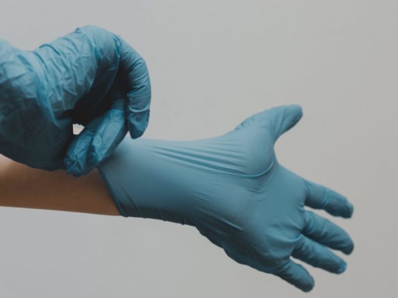 A photo of someone with blue medical gloves.