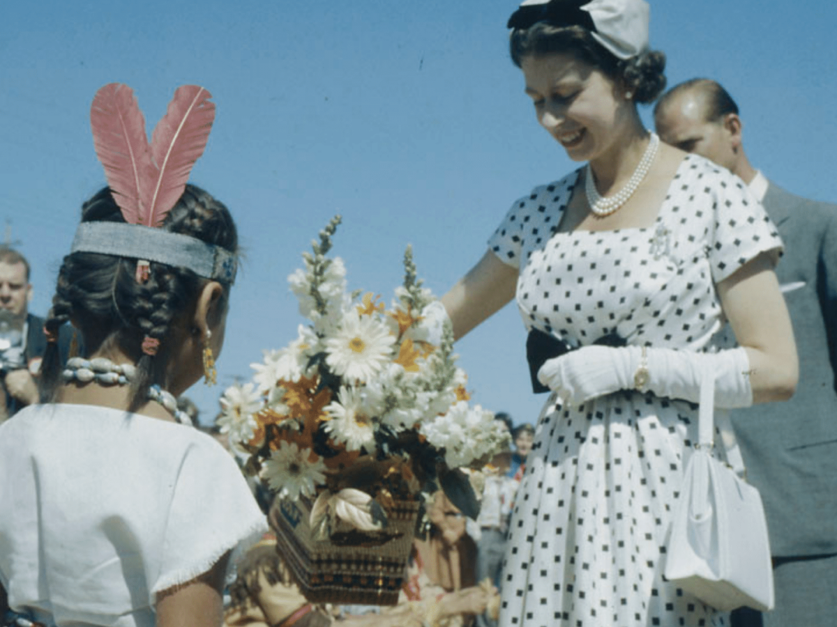 A photo of Queen Elizabeth and an Indigenous small girl.