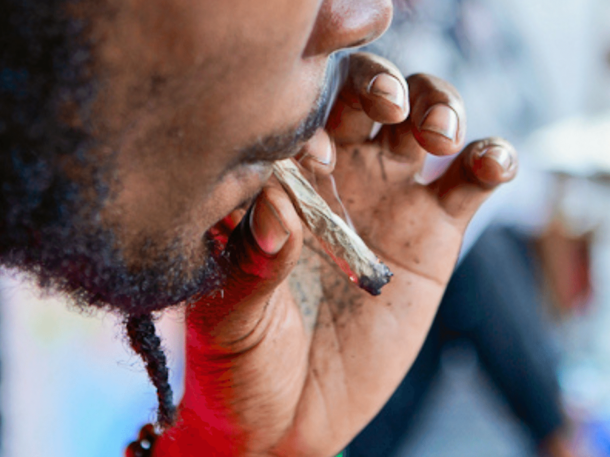 A photo of Lala, a street artist who rolled a cannabis joint while drawing at his informal stall on the corner of Baldwin and Augusta in Toronto