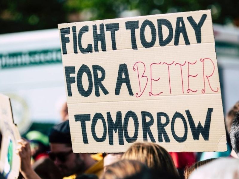 A supporter holding a sign stating 'Fight today for a better tomorrow'