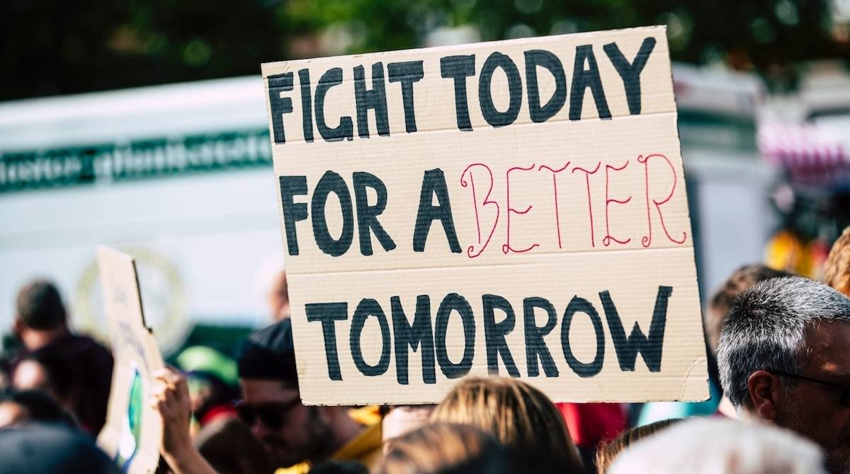 A supporter holding a sign stating 'Fight today for a better tomorrow'
