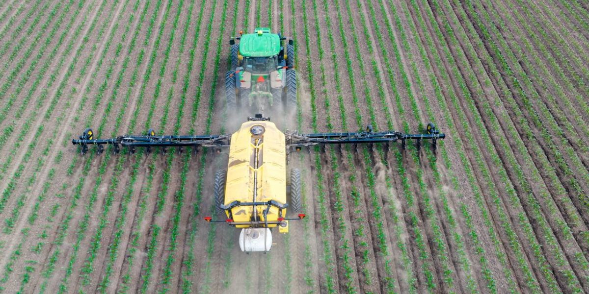 A photo of a tractor spreading fertilizer.