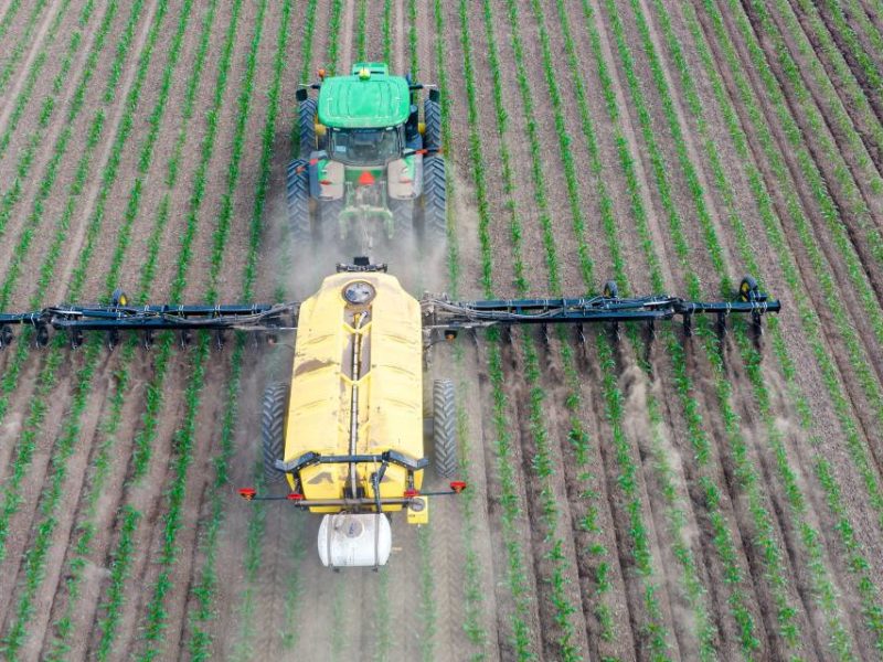 A photo of a tractor spreading fertilizer.