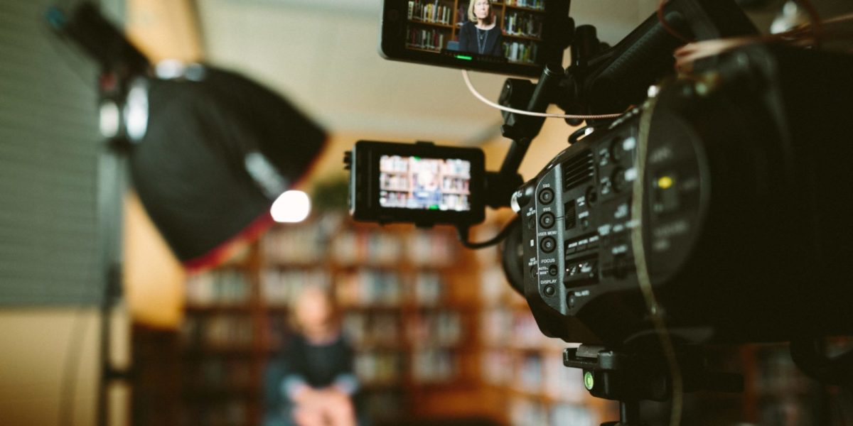 A photo of an interview subject being prepared to be interviewed by a journalist.