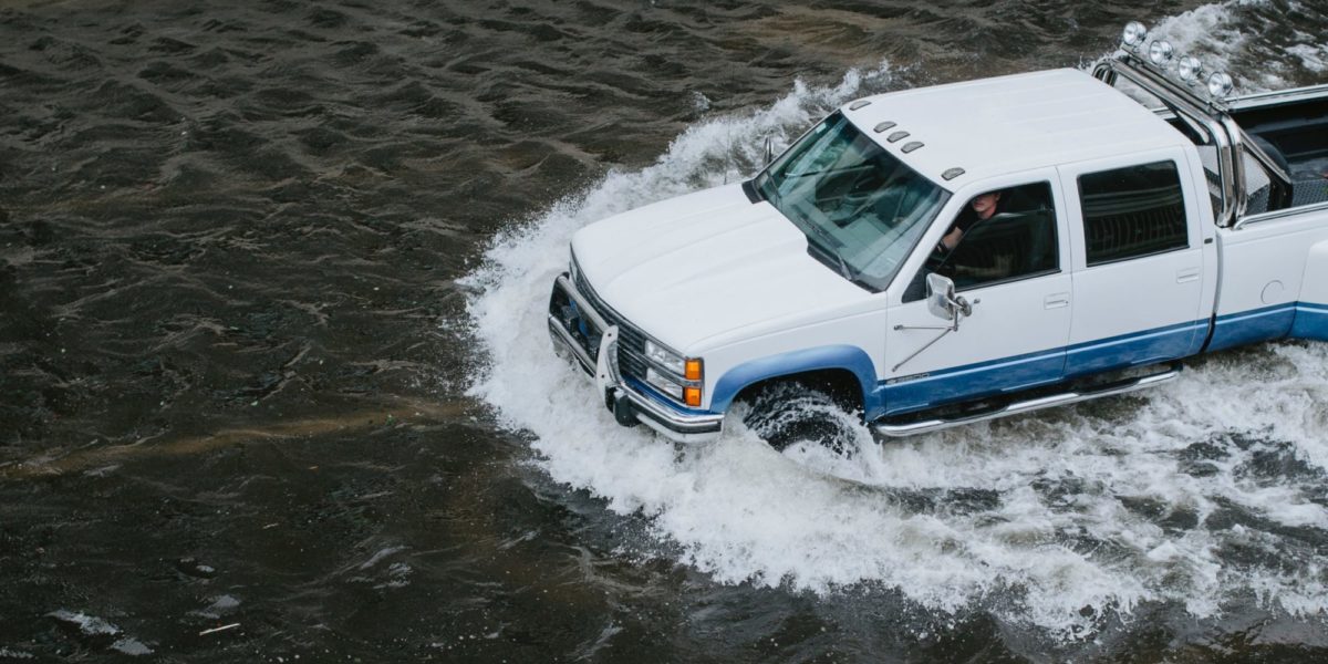 A photo of a truck half way submerged in water