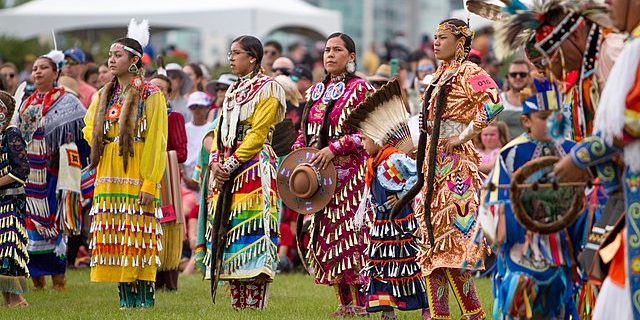 A photo of First Nations dancers watching the Canada Day celebrations