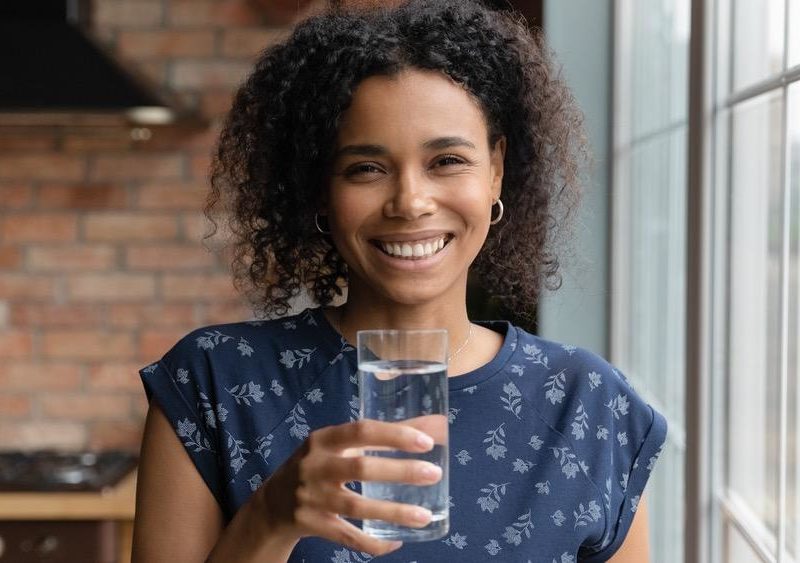 Photo of a woman holding a glass of water