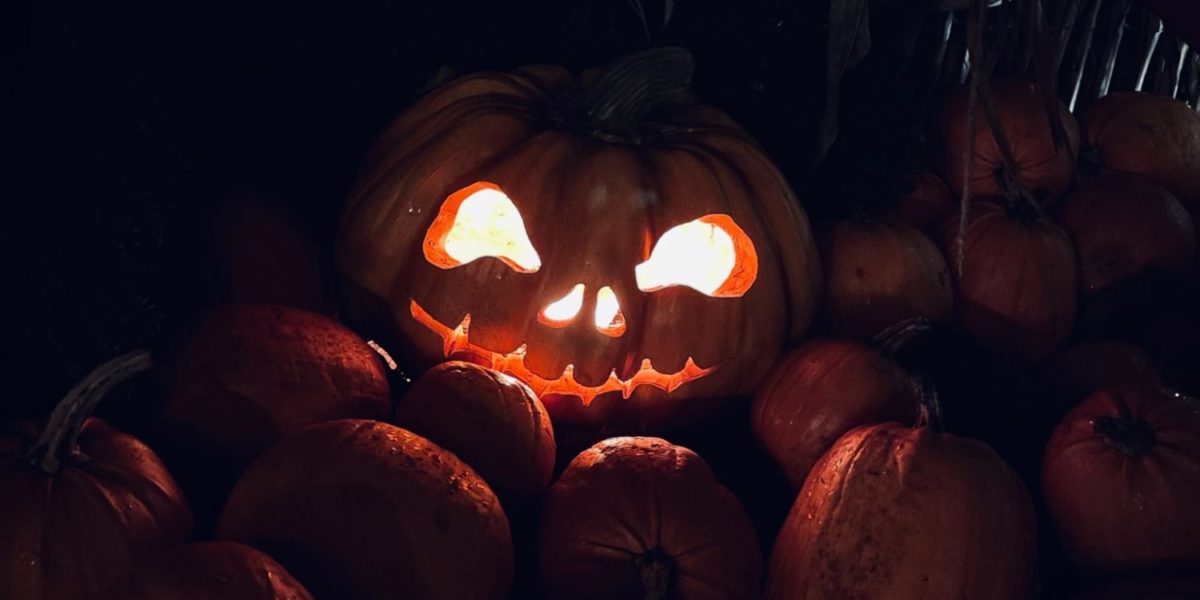 A photo of a jack-o-lantern with a scary face carved into it.