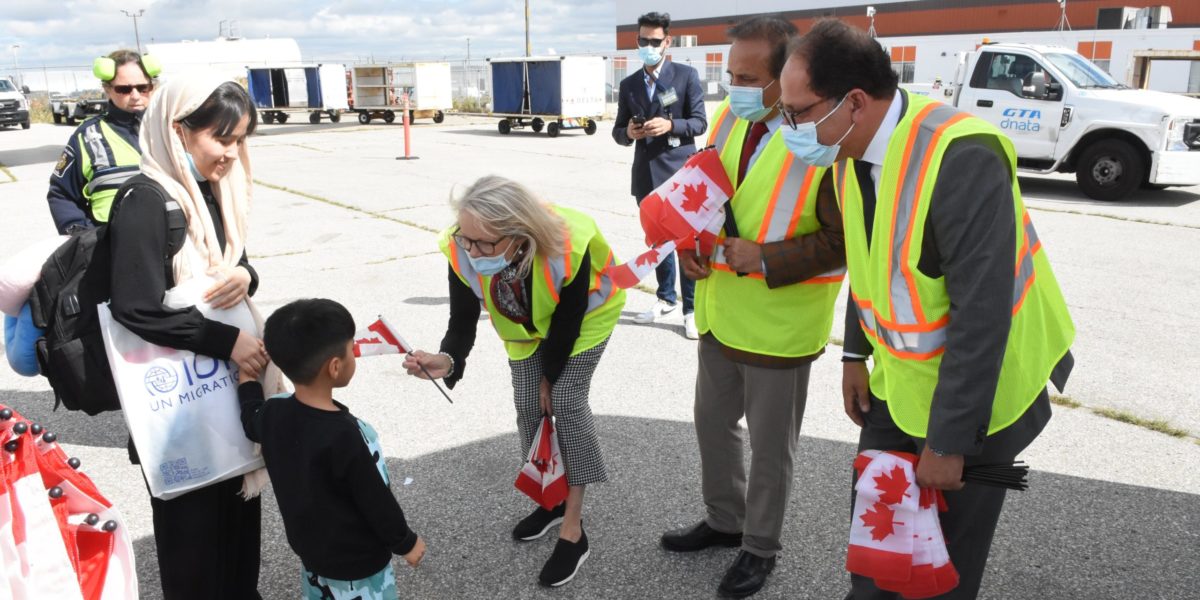 Immigrants being welcomed to Canada by representatives from Immigration Refugees and Citizenship Canada.