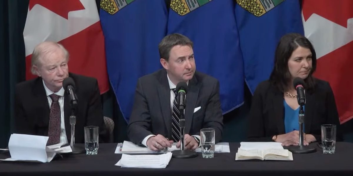 A screenshot of Dr. John Cowell, sole administrator of Alberta Health Services, Health Minister Jason Copping, and Premier Danielle Smith at yesterday’s news conference.