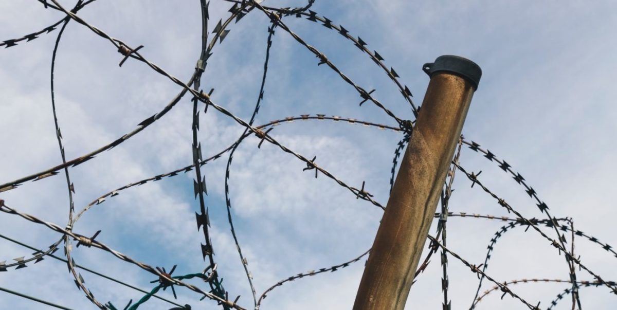 A photo of a barbed wire top of a fence.