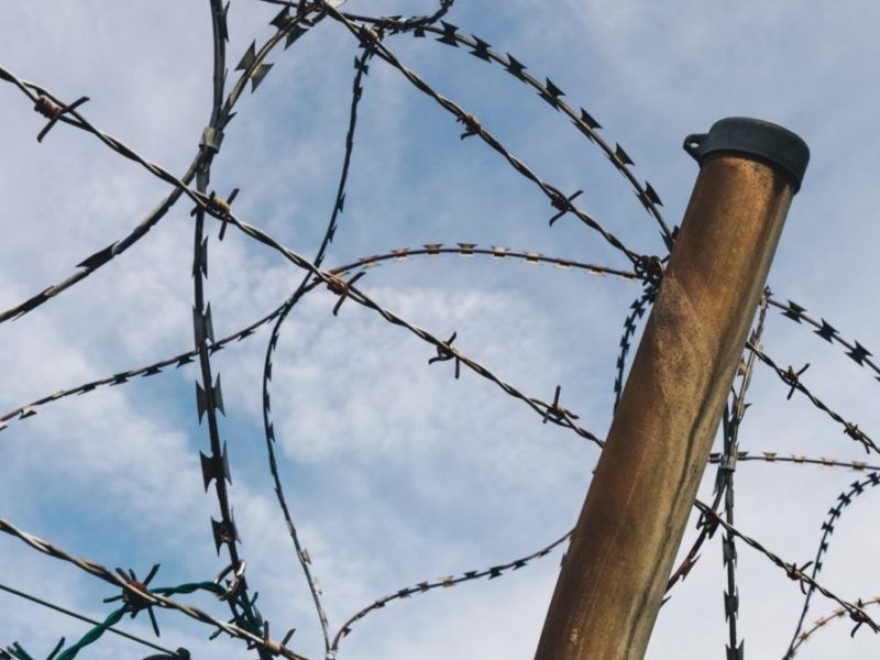 A photo of a barbed wire top of a fence.