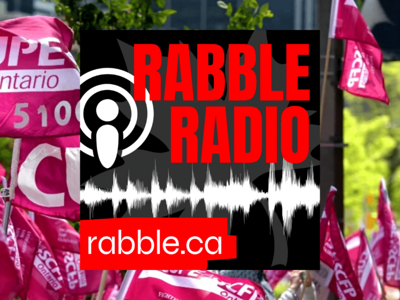 A photo of CUPE signs behind a rabble radio logo.