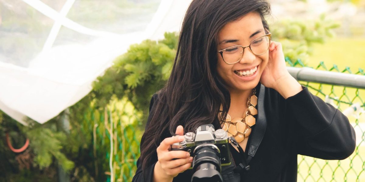 Kiah Lucero smiling and holding a camera.