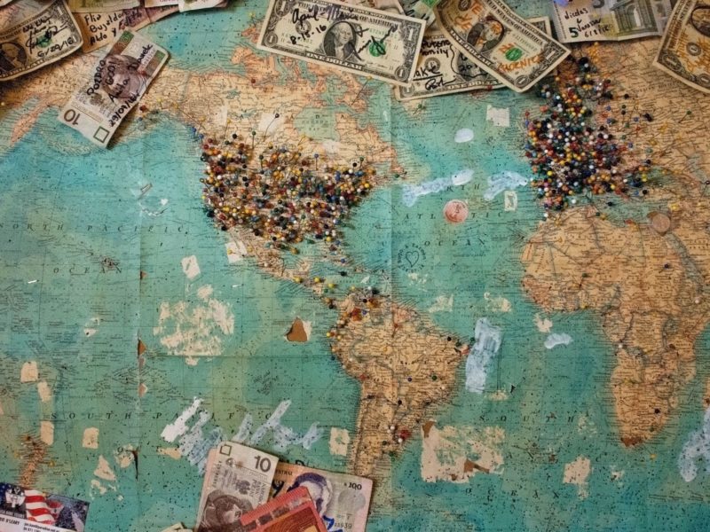 An image of some money laid around a map of the world