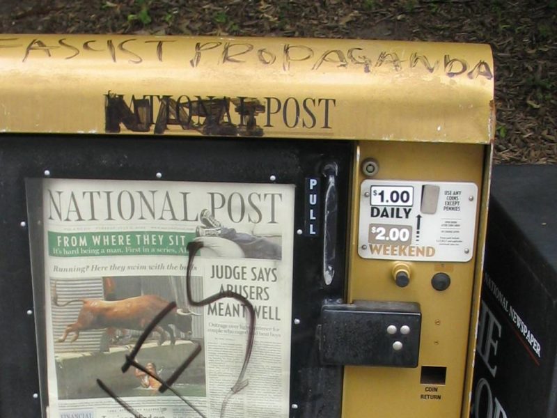 A vandalized National Post news box.