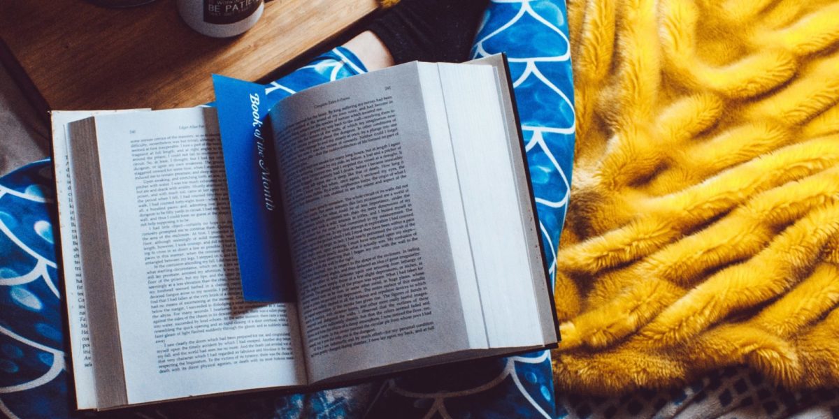 A book is settled on a table with a bookmark inside of two pages.