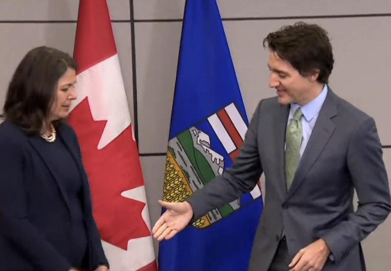 Alberta Premier Danielle Smith tries to snatch back her hand from Prime Minister Justin Trudeau.