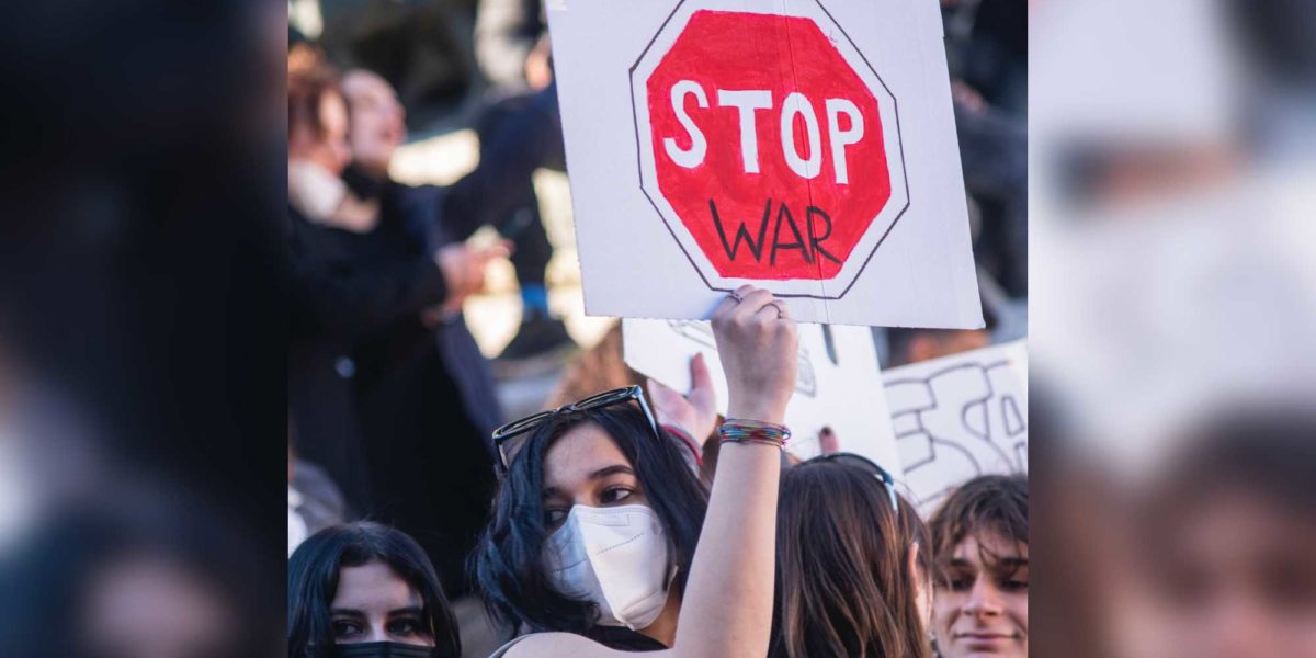 A protester holding a sign calling for an end to war.