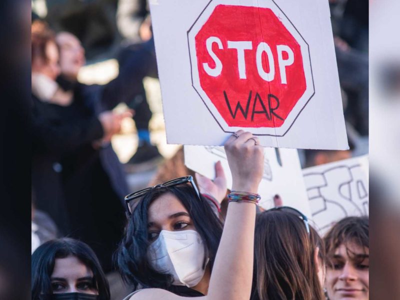 A protester holding a sign calling for an end to war.