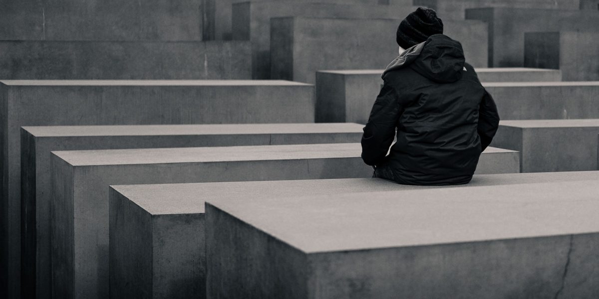 A child sits on a stone monument at the Berlin Memorial for the murdered Jews of Europe.