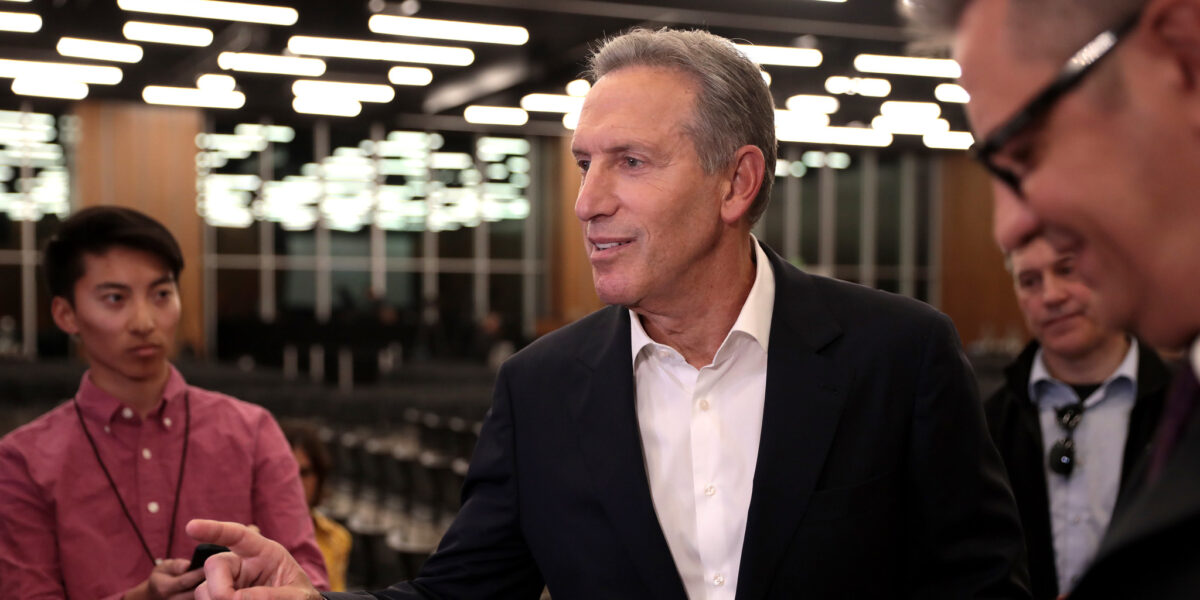 An image of Howard Schultz, former CEO of Starbucks, speaking with the media at an event at Arizona State University.