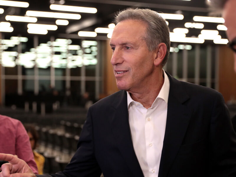 An image of Howard Schultz, former CEO of Starbucks, speaking with the media at an event at Arizona State University.