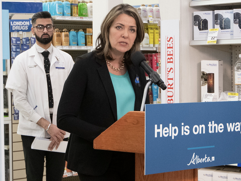 Alberta Premier Danielle Smith with a pharmacist in a pharmacy.