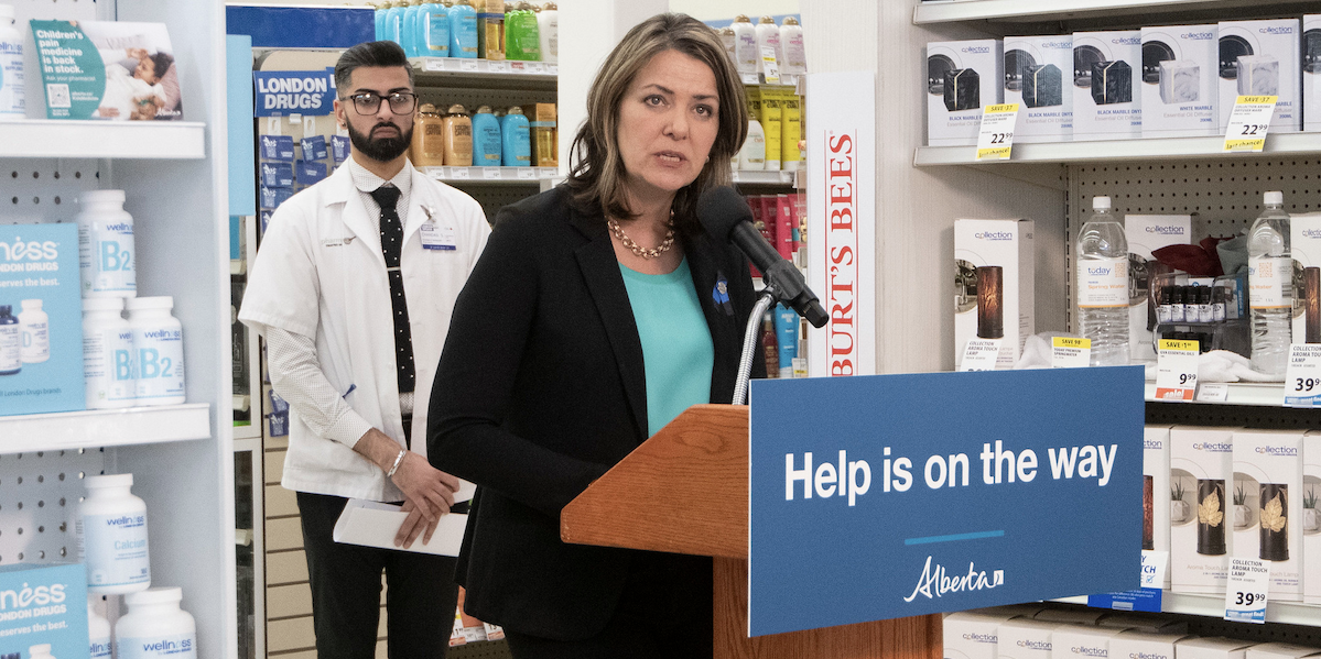 Alberta Premier Danielle Smith with a pharmacist in a pharmacy.