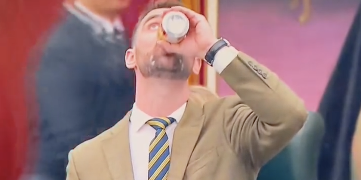 MLA Dan Williams chugs a beer in the Alberta Legislature.