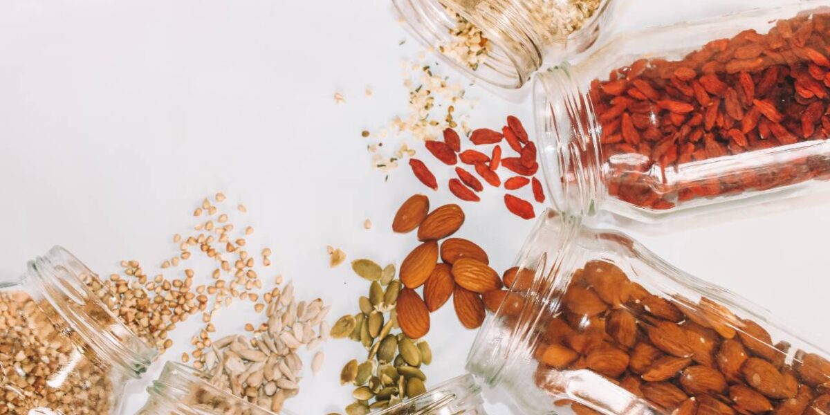 A variety of seeds being spilled onto a white surface.