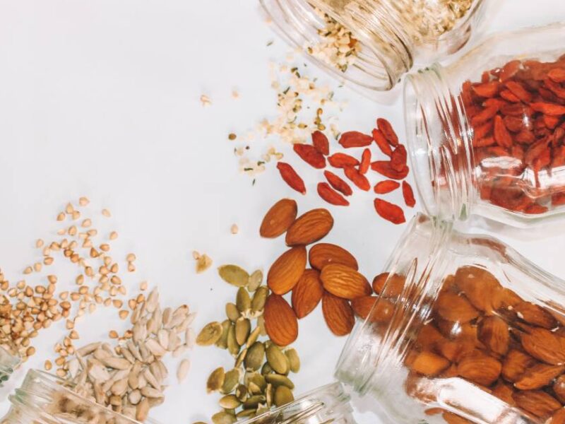 A variety of seeds being spilled onto a white surface.