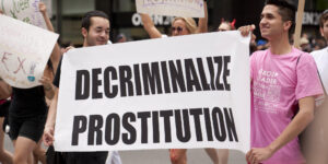 Participants in 2011 NYC Pride parade hold a sign reading "decriminalize prostitution." Advocates say sex work convictions should be considered historical wrongs and expunged.