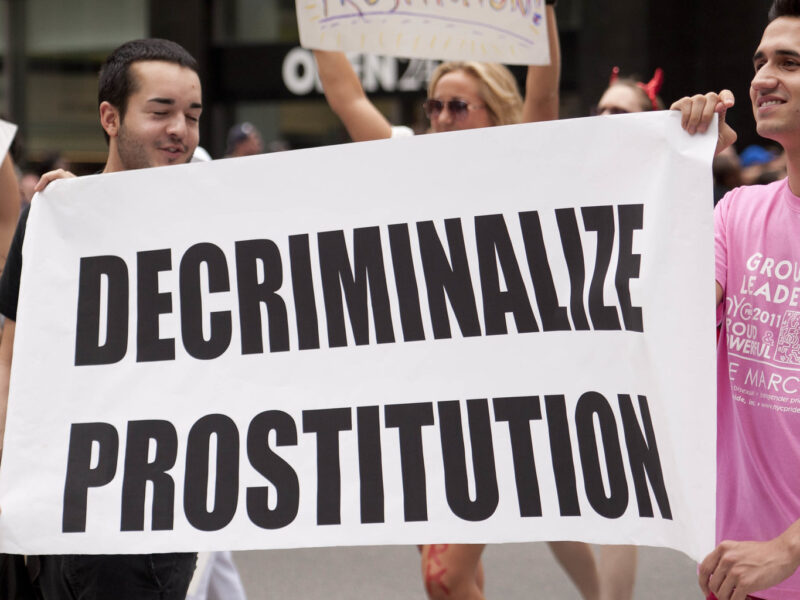 Participants in 2011 NYC Pride parade hold a sign reading "decriminalize prostitution." Advocates say sex work convictions should be considered historical wrongs and expunged.