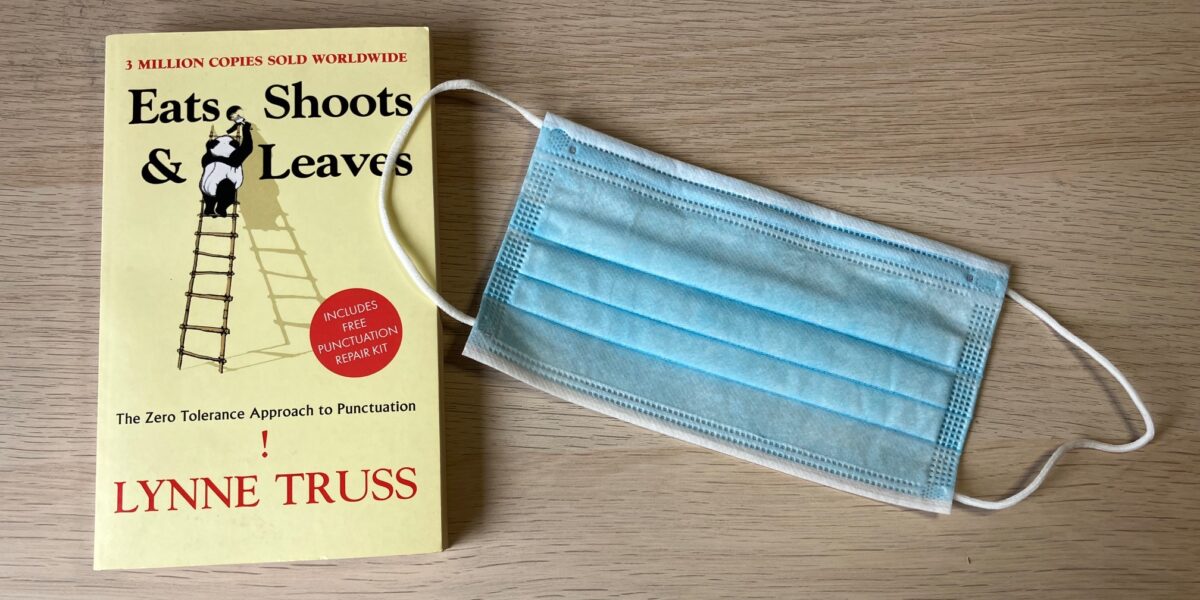 An image of the punctuation book "Eats, Shoots & Leaves" next to a surgical mask used during the COVID-19 pandemic.