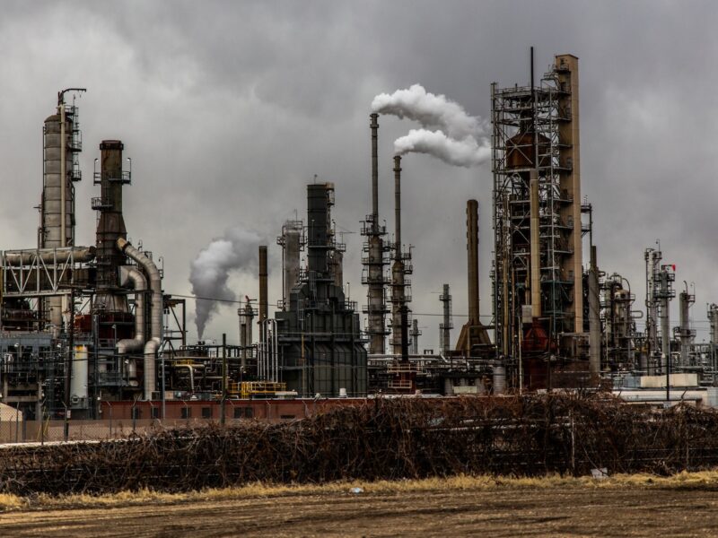 Image of an oil refinery with smoke stacks.