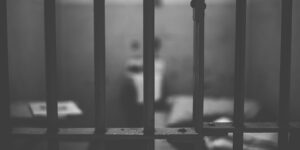 A view behind the bars of a prison cell.