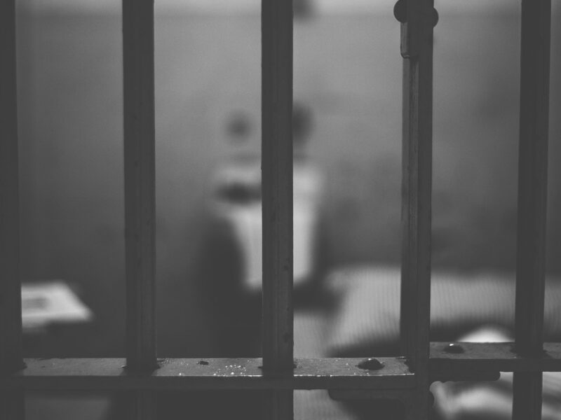 A view behind the bars of a prison cell.