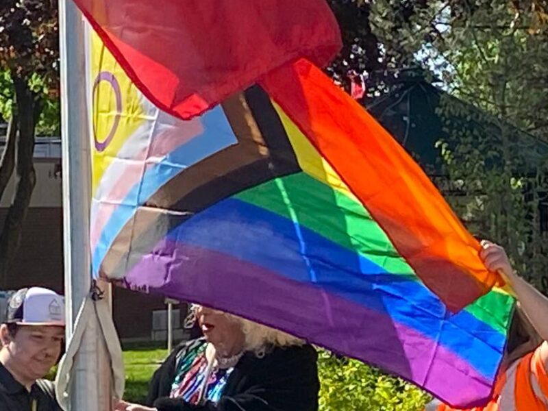 Three people raise a 2SLGBTQIA_ flag on the International Day against Transphobia, Homophobia and Biphobia in Cornwall, Ontario on Wednesday, May 17, 2023.