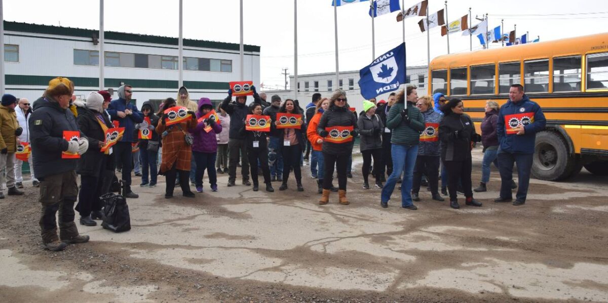 Members of PSAC-NEU who have been locked out by the IHA demonstrating outside of IHA's offices with a school bus in the background.