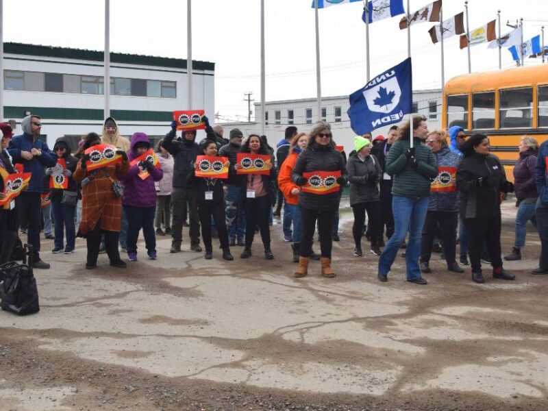 Members of PSAC-NEU who have been locked out by the IHA demonstrating outside of IHA's offices with a school bus in the background.