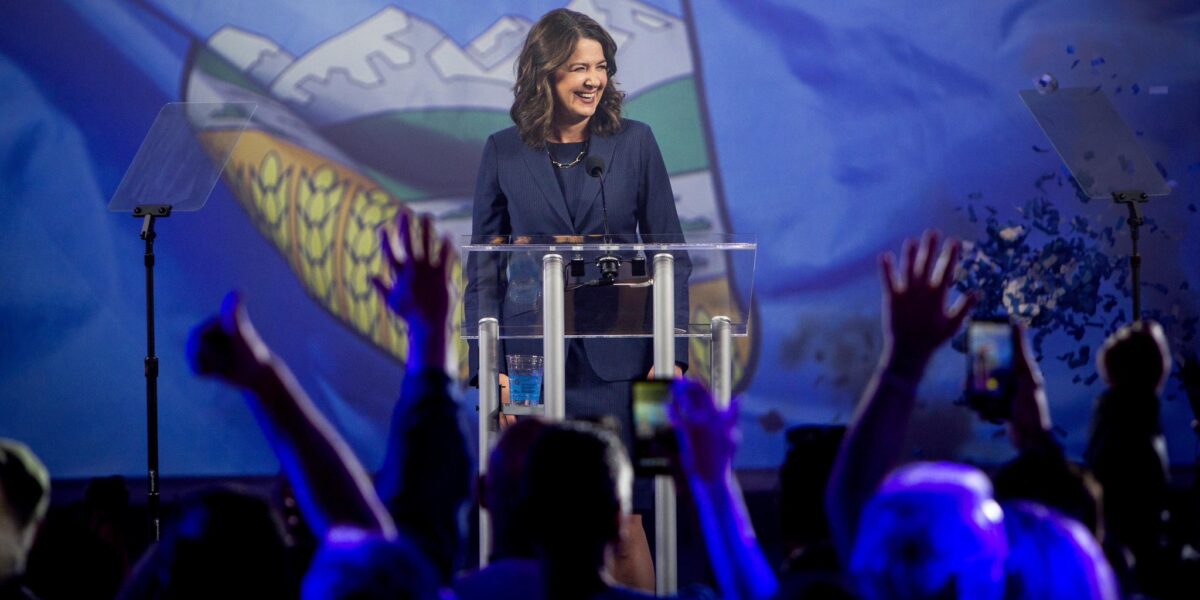 Alberta Premier Danielle Smith stands in front of a large image of the Alberta flag on stage during her victory speech on election night May 29, 2023.