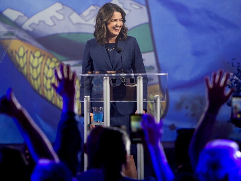 Alberta Premier Danielle Smith stands in front of a large image of the Alberta flag on stage during her victory speech on election night May 29, 2023.