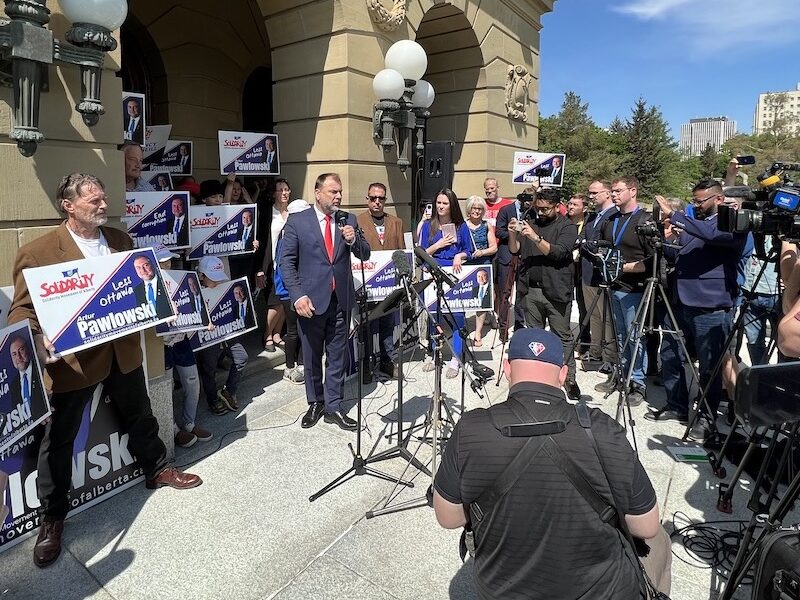 Street preacher Artur Pawlowski flanked by his supporters and facing the media on the steps of the Legislature in Edmonton.