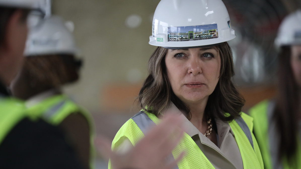 Alberta Premier Danielle Smith posing in a hard hat.